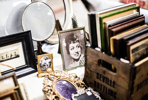 Old frames and books displayed at an estate sale